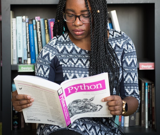 Zwarte vrouw met lesboek over Python